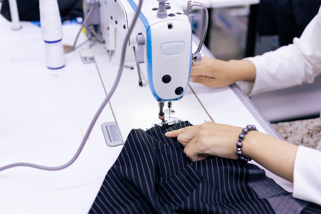 Tailor stitching a uniform made from twill fabric