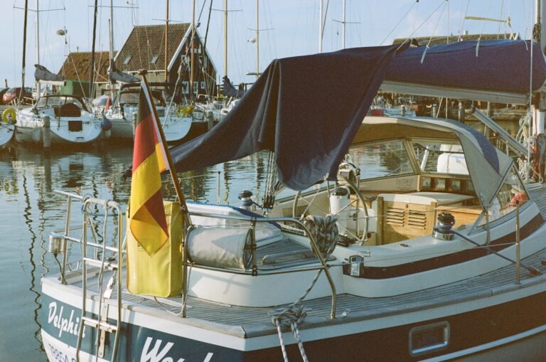 Sailboat docked in a harbour with sail covers